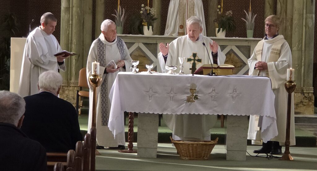 Luxeuil Pilgrims3 - Columban Missionaries Priests at an altar during Mass with a crucifix and chalices on the white cloth altar.