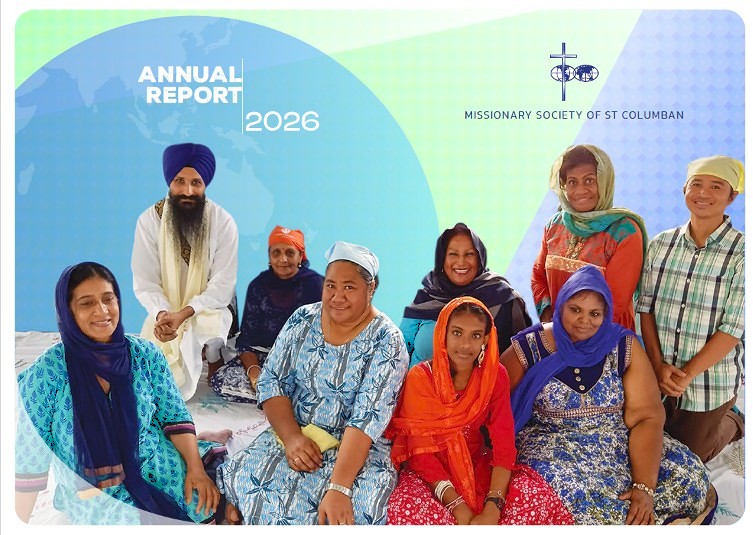 Annual Report 2026 cover showing a diverse group of people in colorful traditional dress, smiling, with a blue-green backdrop and the Missionary Society of St Columban logo and text.
